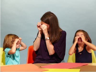 Mom making owl faces and being silly with her two girls in article about using laughter in parenting struggles