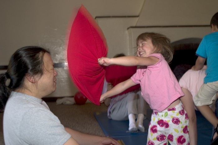 Dad and daughter happily pillow fight