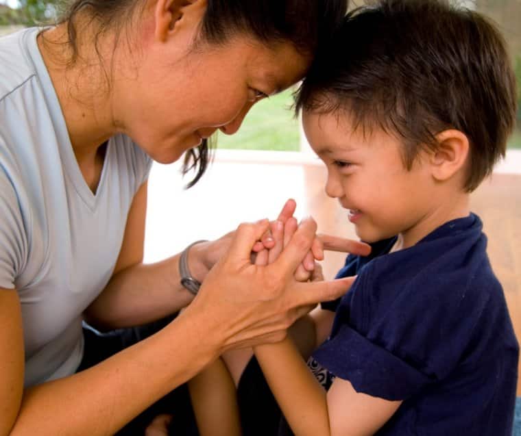 Mom and son smile and hold hands