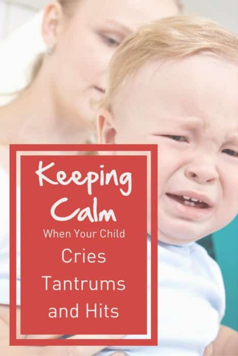 toddler boy crying with mom in background