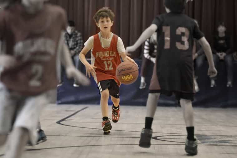 boy playing basketball gets laughed at by teammates