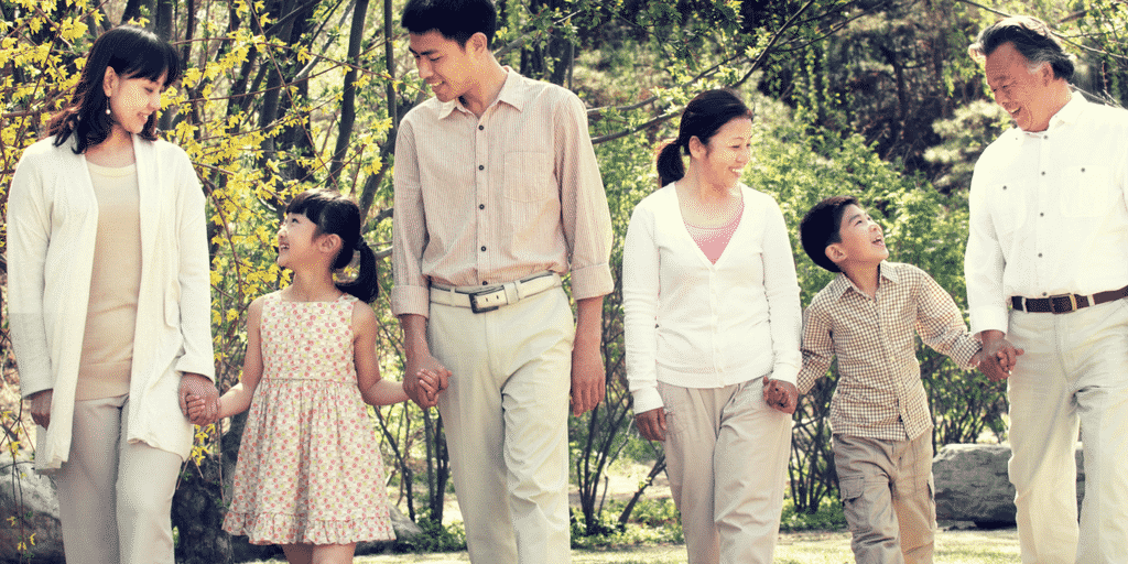 mom, dad, children and grandparents walking hand in hand in post about parenting as a team