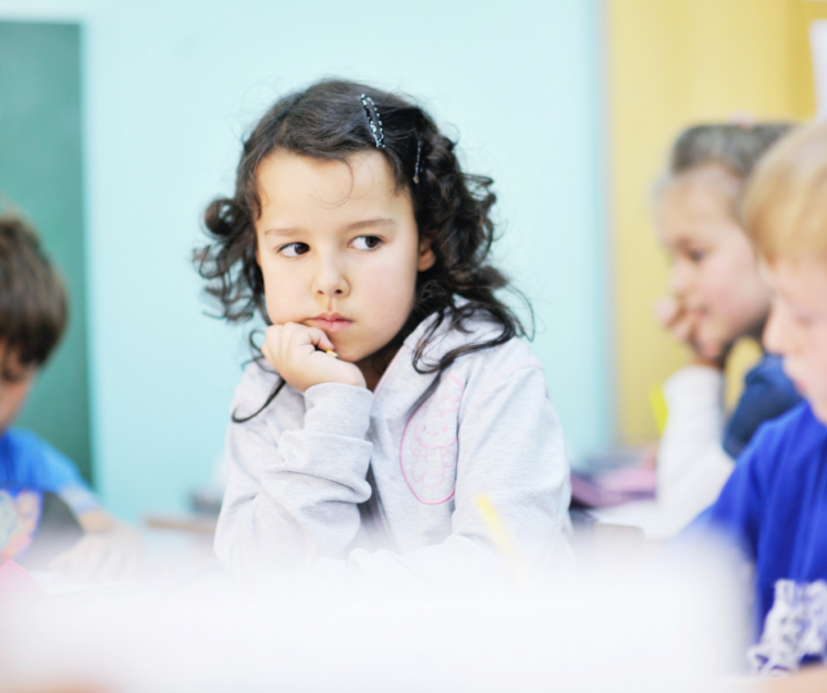 Little girl in preschool classroom looking disconnected and uninvolved