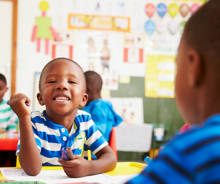 Cute preschool boy looking happy and connected in trauma-sensitive classroom