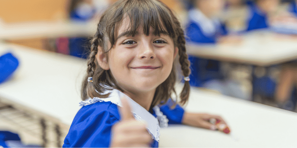 School girl smiling in a post about making the back to school transition easier