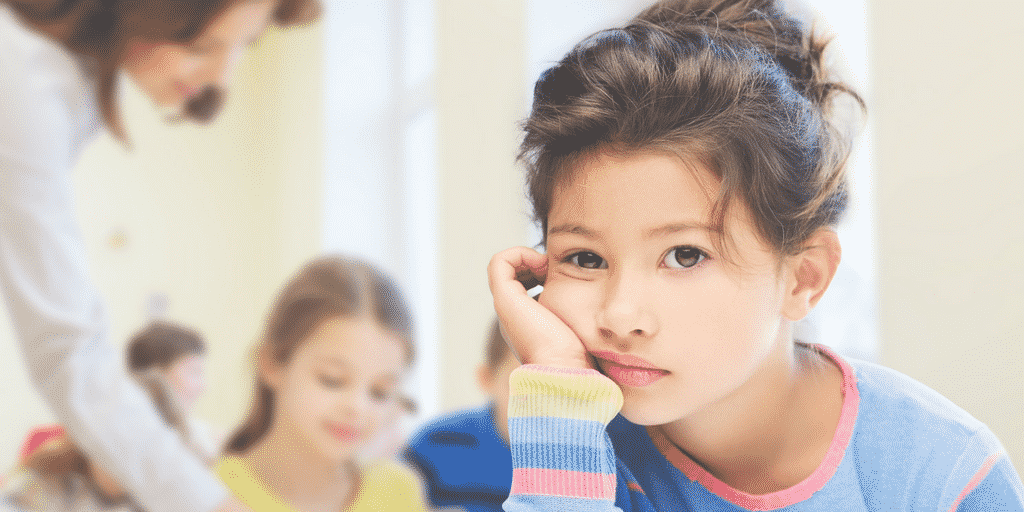 Girl looking unhappy at school in post about how to tell if school is stressing your child