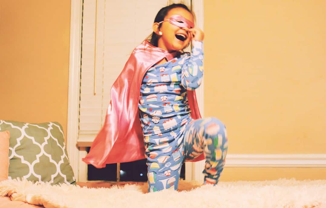 girl in pyjamas and superhero cape in a post about child getting scared at bedtime