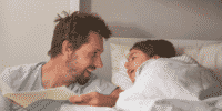 Father and child laughing at bedtime story