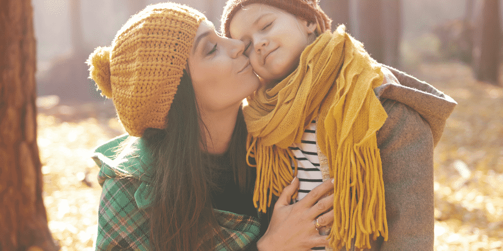 Mom kissing smiling child on cheek