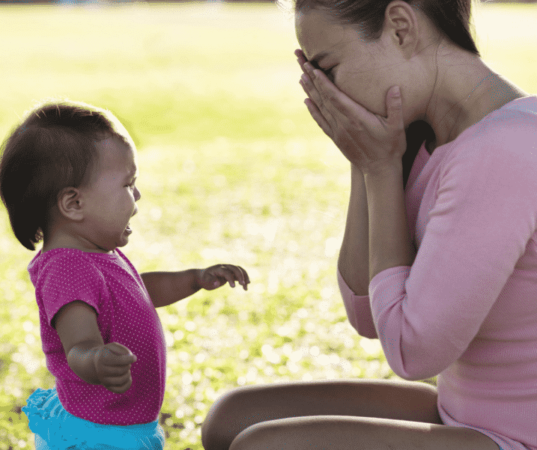 Baby crying with overwhelmed mom