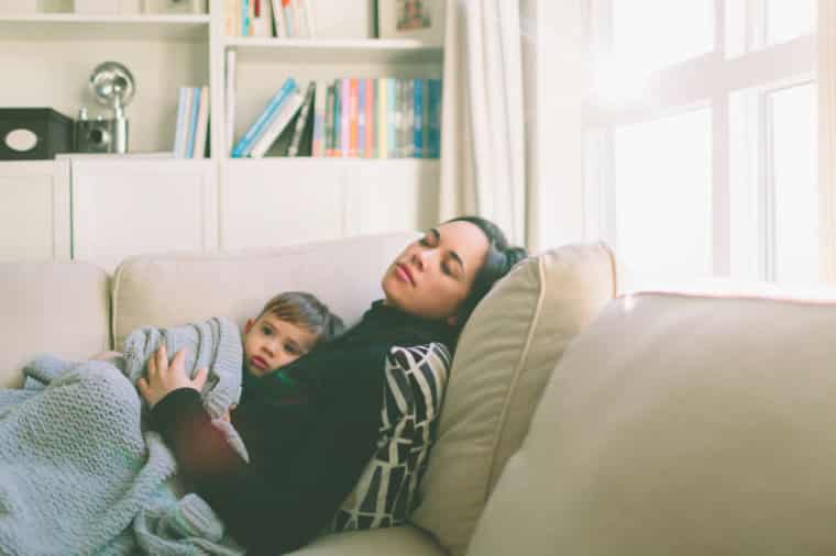 Patient Parent Tired mom napping on couch with toddler son