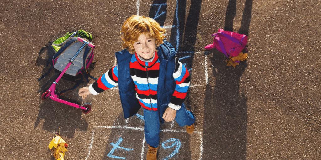 Boy looking happy playing hopscotch