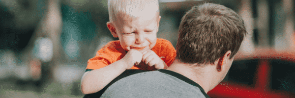 Dad calmly holding toddler having a tantrum