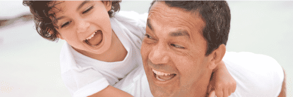 Dad smiling giving son a piggyback in article about one parent using Hand in Hand Parenting