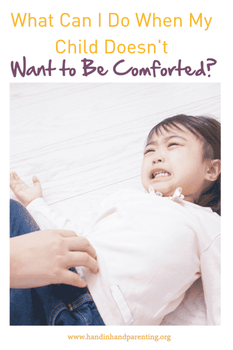 Crying girl wriggling away from parent