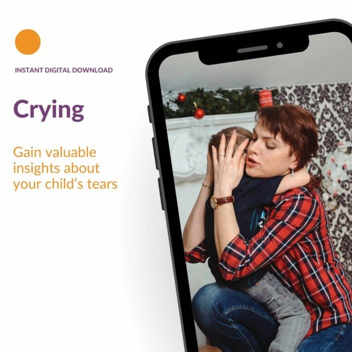 Child crying in parents' arms, their face hidden in parent's shoulder.